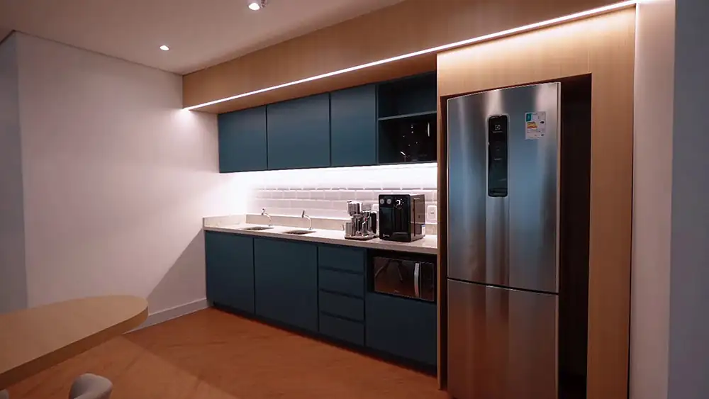 Copa corporativa da Oceaneering no Rio de Janeiro, desenvolvida pela Custódio em um projeto de arquitetura corporativa que combina marcenaria moderna, iluminação funcional e espaço de apoio acolhedor para os colaboradores.