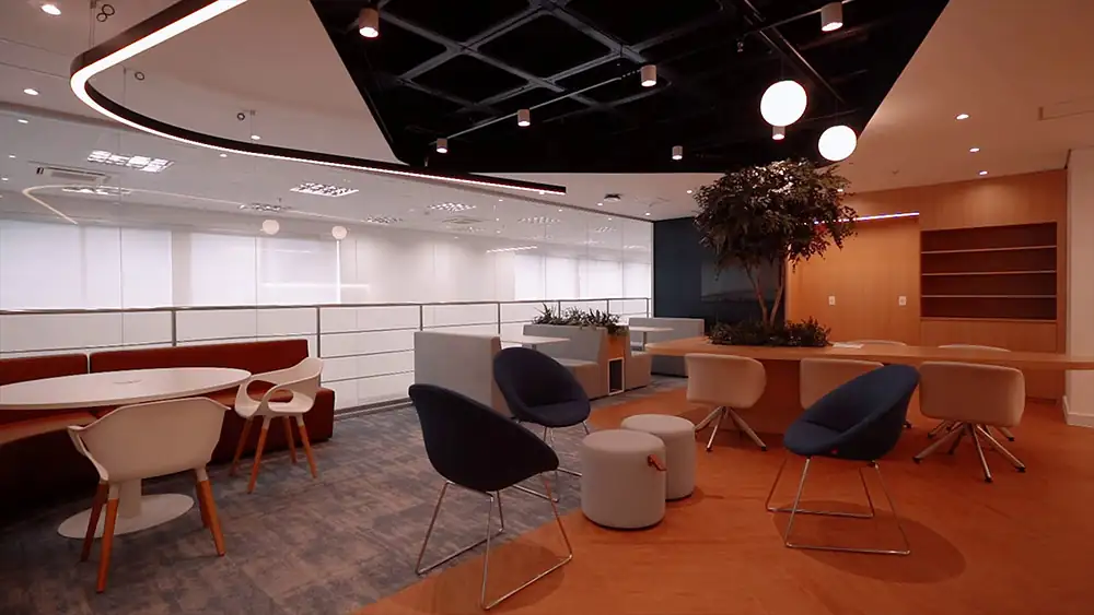Área de copa e convivência da Oceaneering no Rio de Janeiro, projetada pela Custódio em um projeto de arquitetura corporativa que integra mobiliário moderno, luz cênica e espaço acolhedor para pausas e interação dos colaboradores.