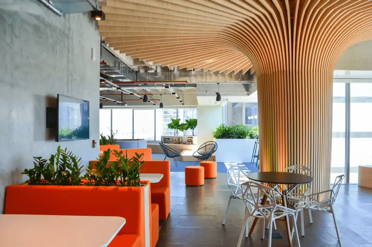 Área de convivência da EDF com booths laranja e marcenaria escultural, parte de um projeto de arquitetura desenvolvido por escritório de arquitetura especializado em obra corporativa.