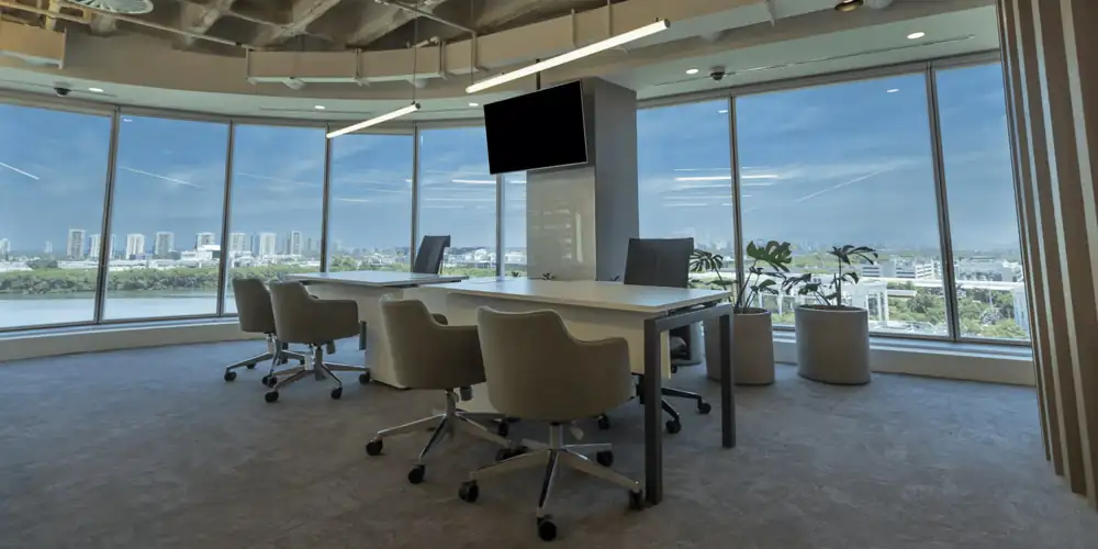 Sala de reunião da Huawei com mesa ampla, cadeiras giratórias cinza e vista panorâmica, integrada a um projeto de arquitetura que valoriza iluminação natural, dentro de uma obra corporativa e reforma de escritório executada pelo escritório de arquitetura.