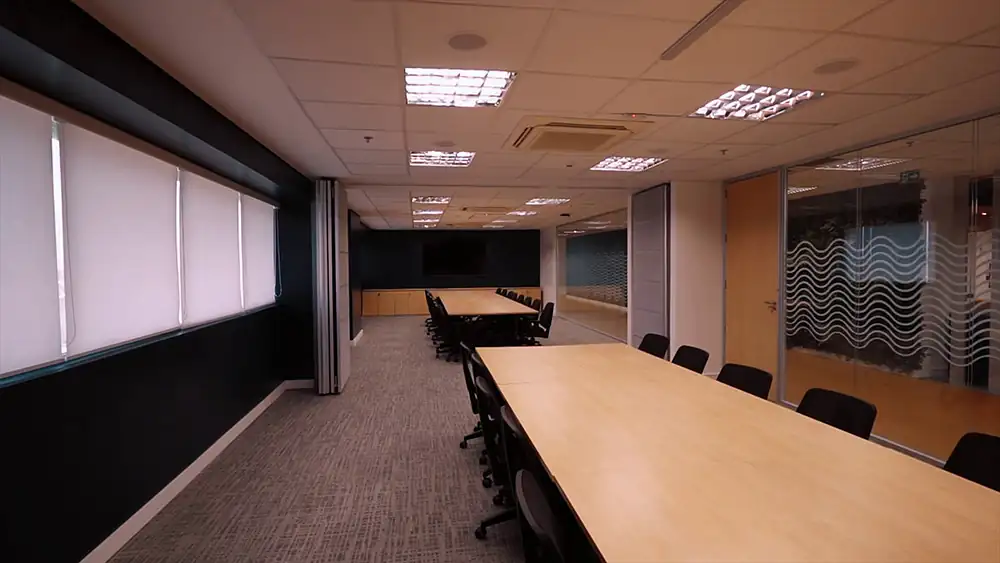 Sala de reunião expandida da Oceaneering no Rio de Janeiro, com divisórias retráteis abertas. Projeto de arquitetura corporativa da Custódio, valorizando flexibilidade, funcionalidade e eficiência nos ambientes de trabalho.