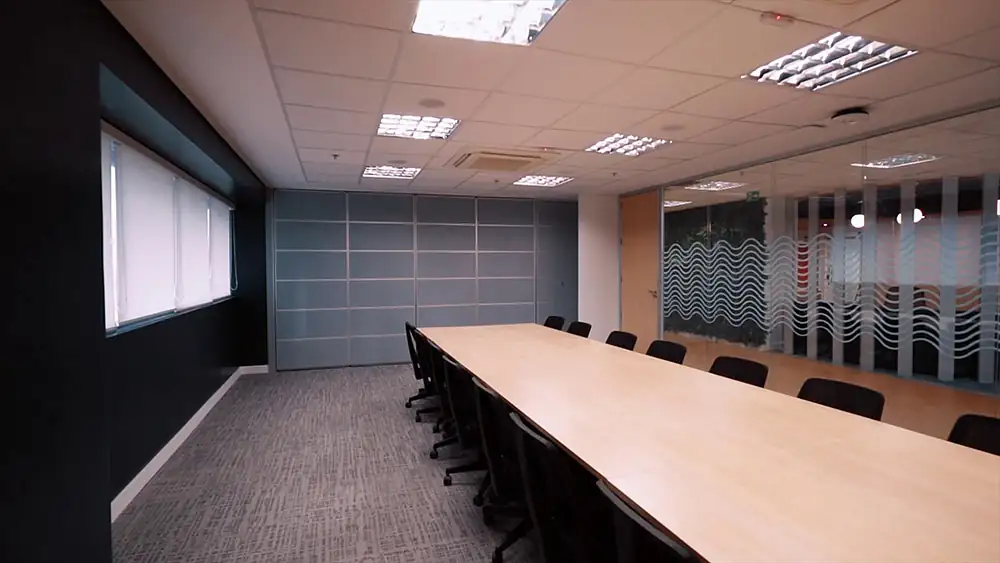 Sala de reunião da Oceaneering no Rio de Janeiro com divisória retrátil, projetada pela Custódio. Reforma de escritório corporativo que valoriza flexibilidade, integração e eficiência nos espaços de trabalho.