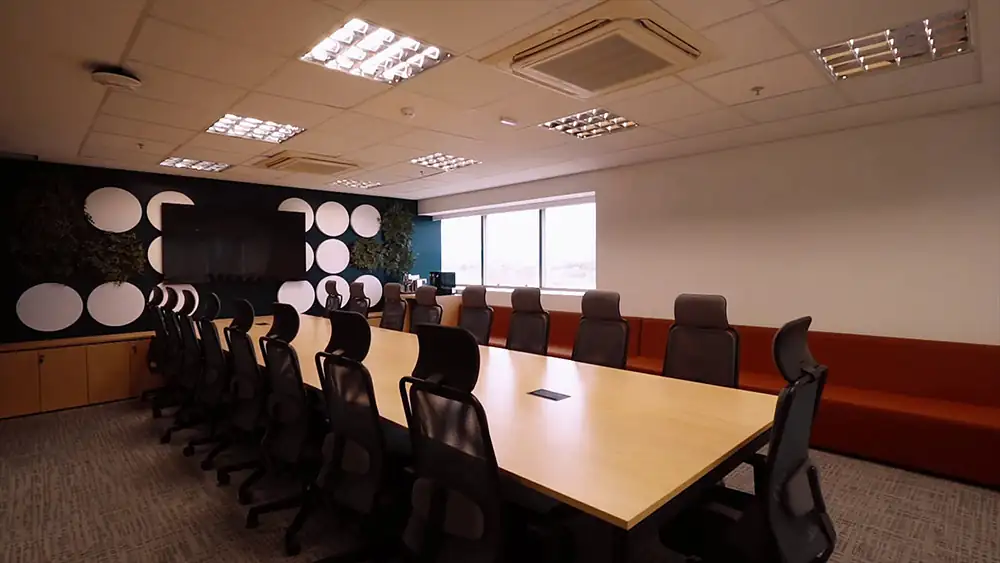 Sala de reunião da Oceaneering no Rio de Janeiro, desenvolvida pela Custódio. Projeto de arquitetura corporativa com mesa ampla, cadeiras ergonômicas e painel decorativo, promovendo conforto, funcionalidade e colaboração. Reforma corporativa.