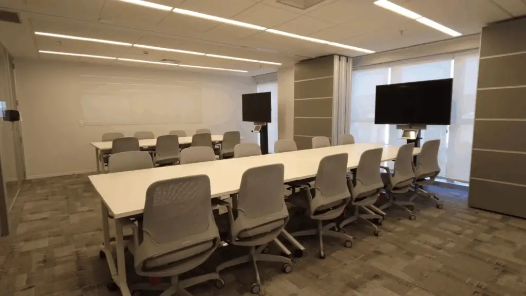 Sala de reunião moderna no escritório da NTS, com mesas amplas, cadeiras ergonômicas e telas de apresentação. Ambiente planejado por escritório de arquitetura, destacando um projeto de arquitetura funcional, obra corporativa bem executada e reforma de escritório voltada para produtividade, conforto e reuniões estratégicas.