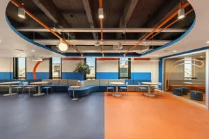 Espaço de convivência do escritório da Recovery, em São Paulo, com bancos curvos projetado em reforma corporativa, destacando soluções de projeto de arquitetura voltadas ao bem-estar.