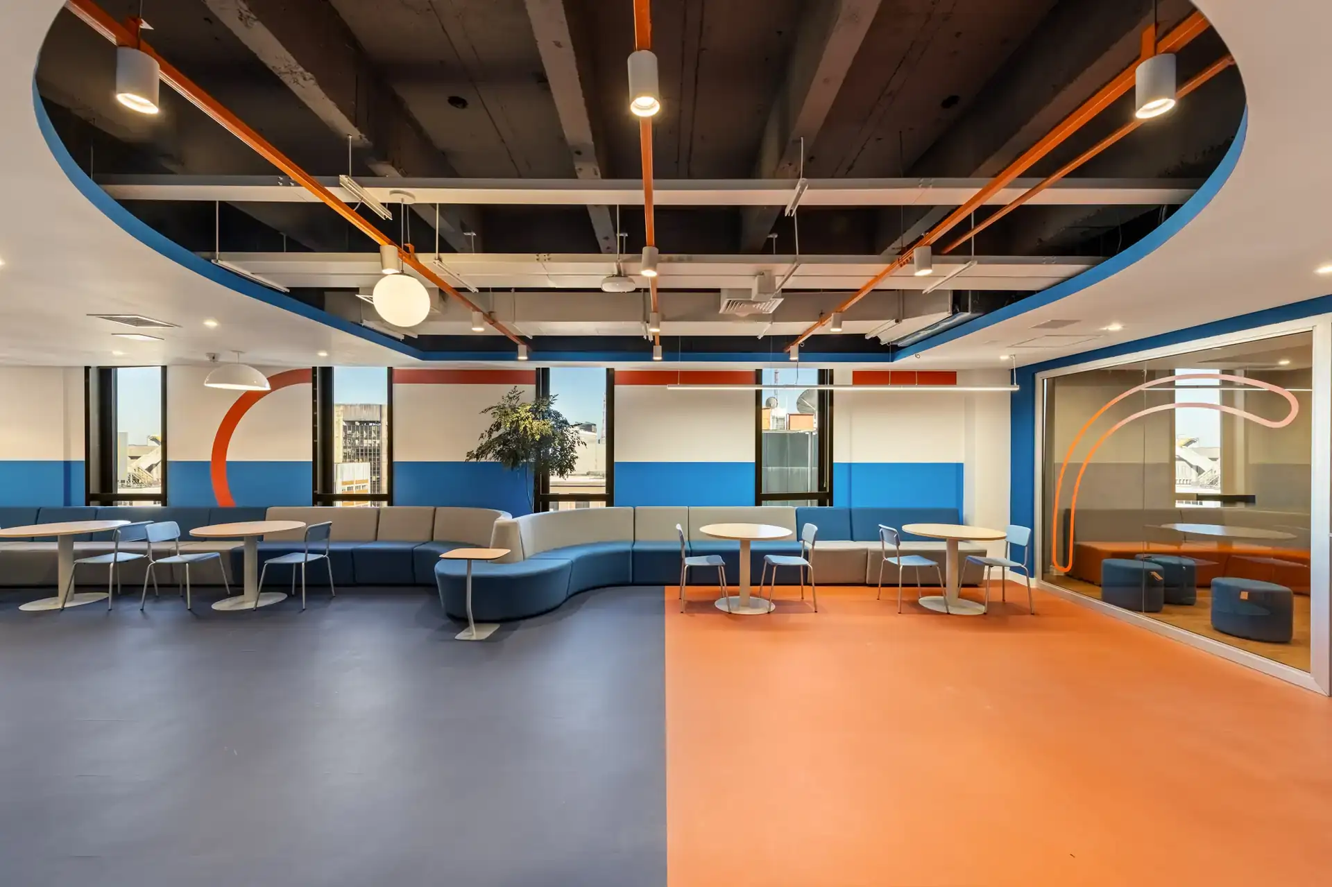 Espaço de convivência do escritório da Recovery, em São Paulo, com bancos curvos projetado em reforma corporativa, destacando soluções de projeto de arquitetura voltadas ao bem-estar.