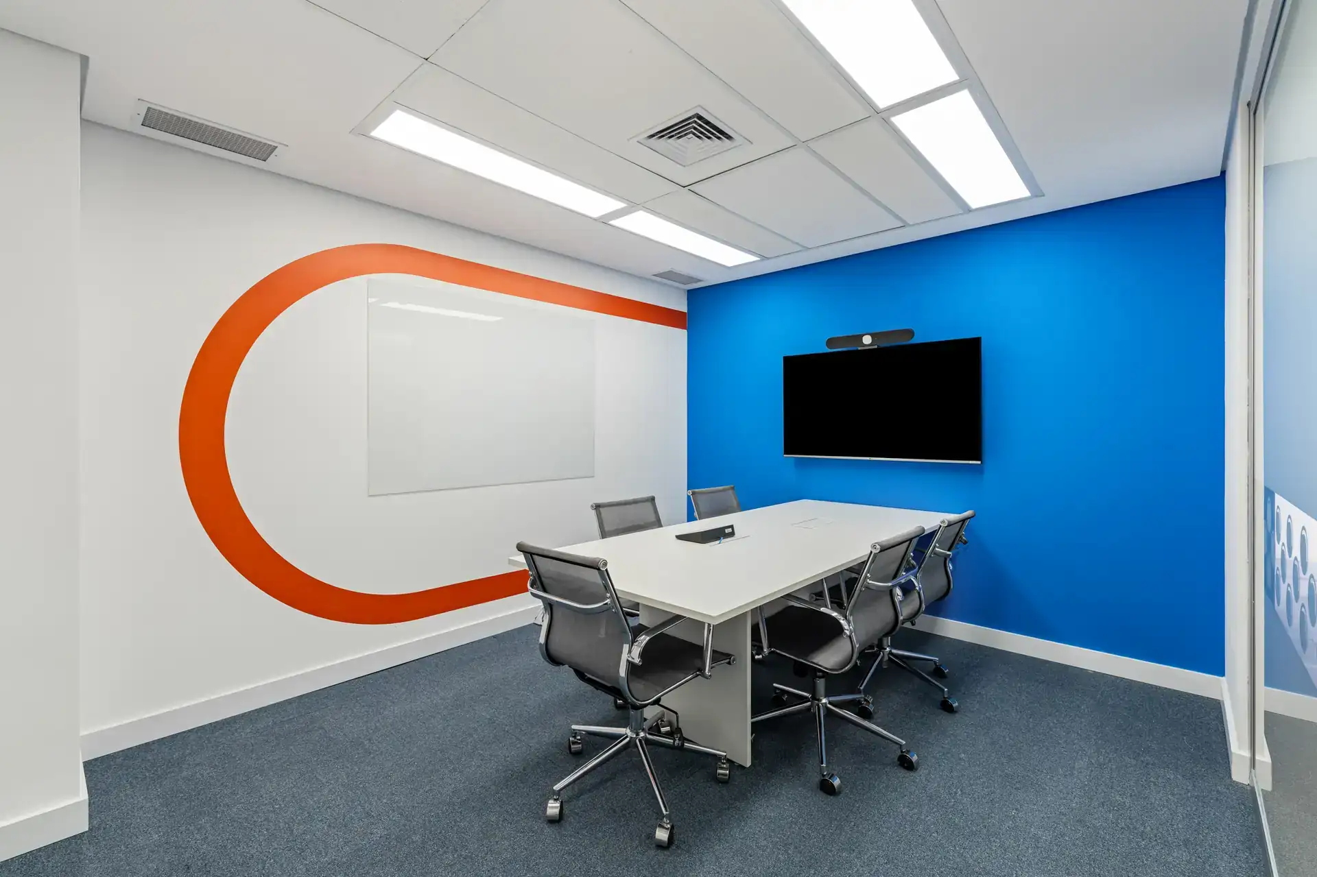 Ambiente de reunião para seis pessoas desenvolvido em projeto de arquitetura corporativa com destaque em azul vibrante.