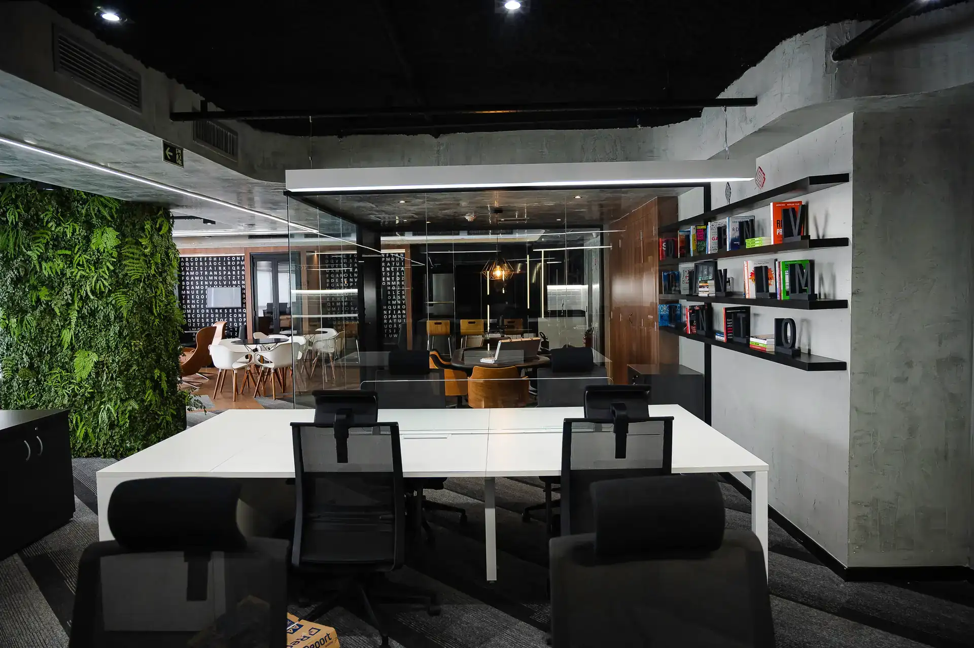 Espaço com estante de livros e área de trabalho integrada, parte de um projeto de arquitetura corporativo da Custódio, destacando soluções de obra corporativa e reforma de escritório.