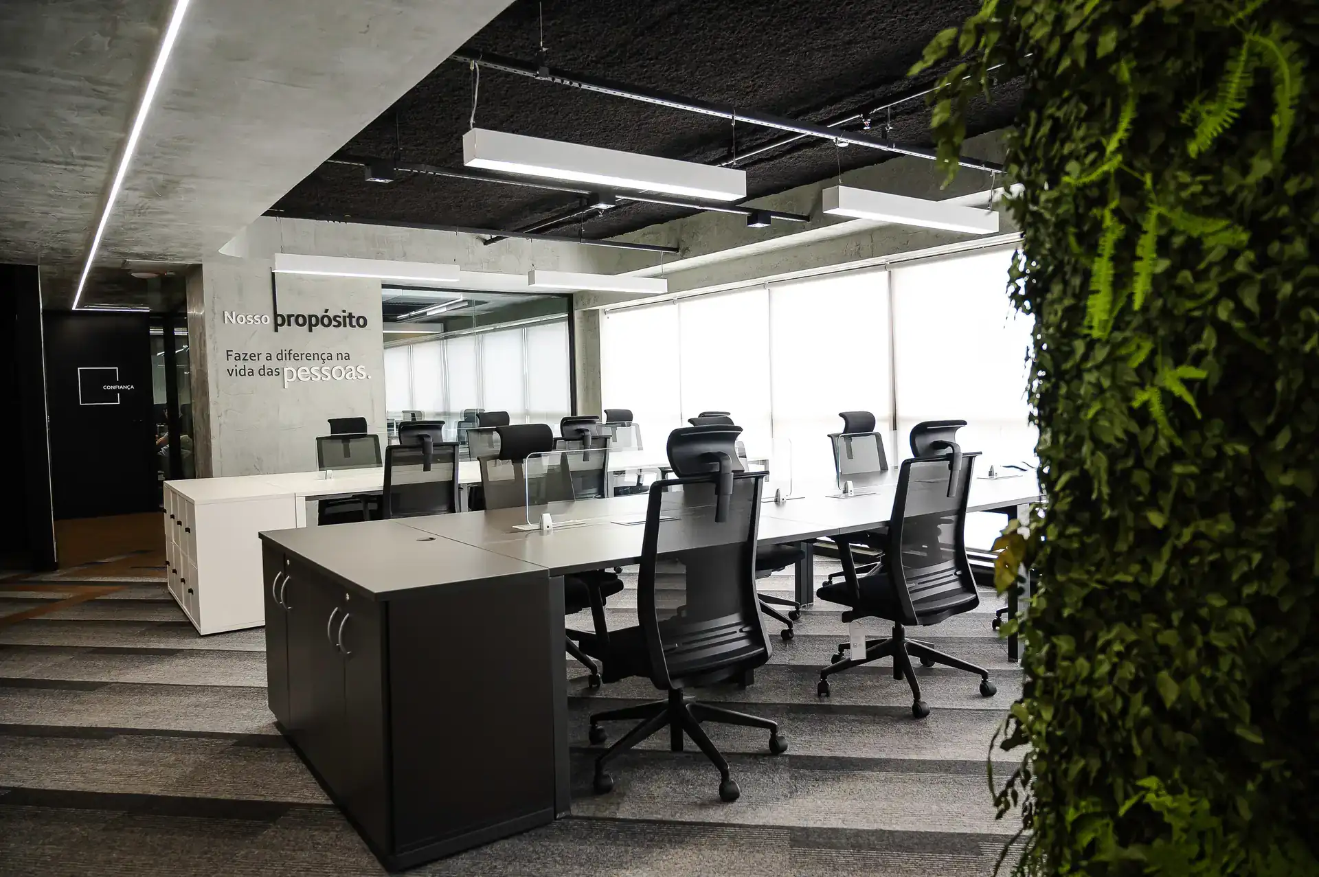 Ambiente amplo de estações de trabalho com iluminação linear, desenvolvido em projeto de arquitetura da Custódio para reforma corporativa no Rio de Janeiro.