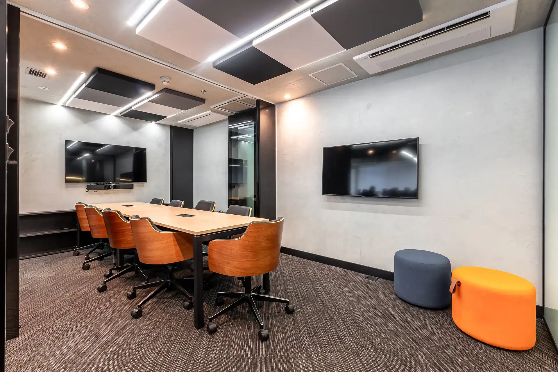 Sala de reunião minimalista com mesa central e TV, destacando soluções de projeto de arquitetura voltadas à funcionalidade e elegância.