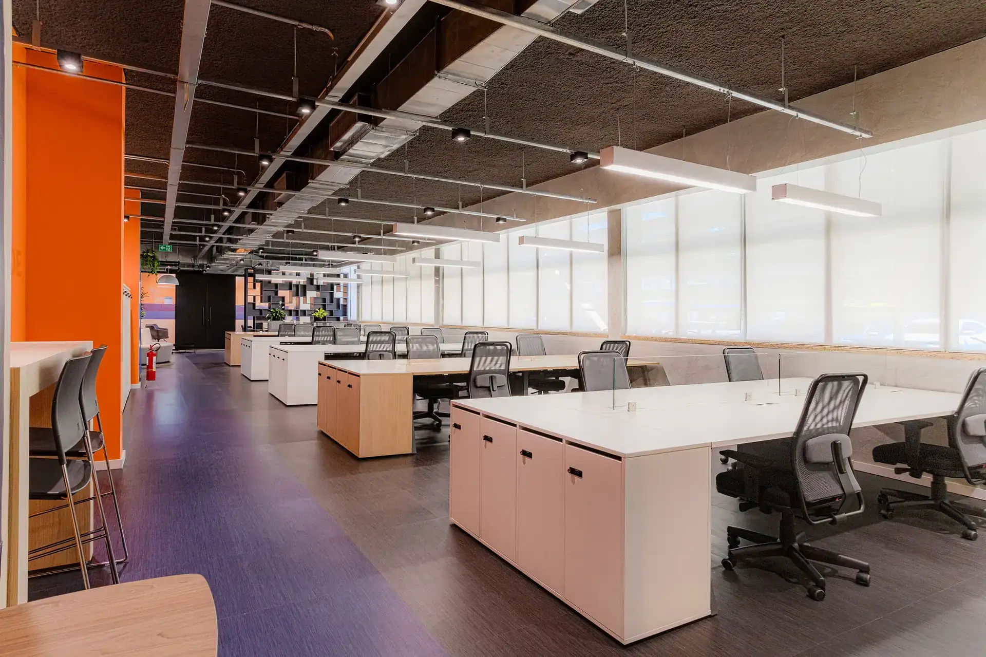 Estações de trabalho da EDF após reforma de escritório executada pela Custódio Arquitetura, com grande área iluminada e mobiliário corporativo moderno.