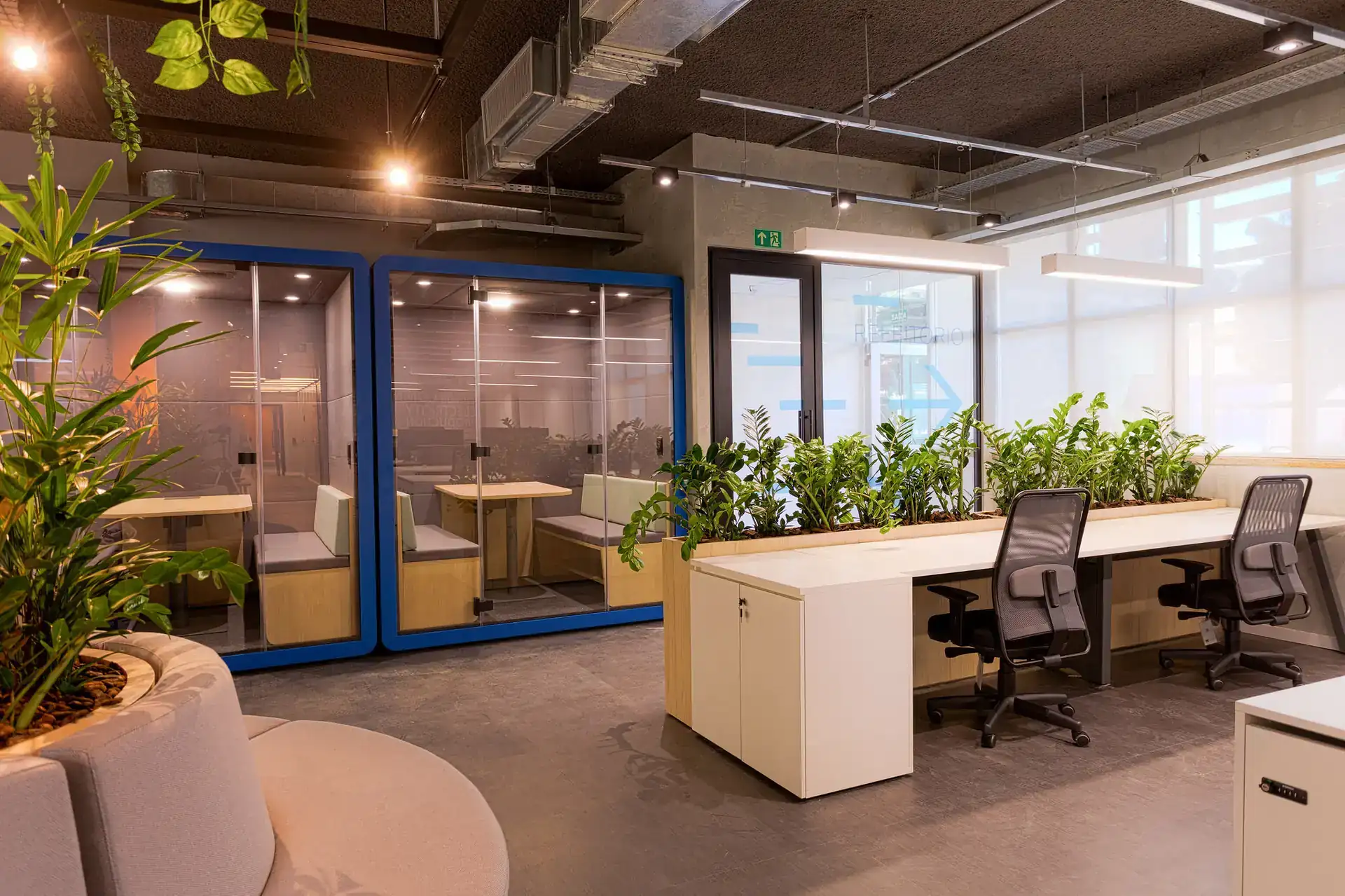 Ambiente colaborativo da EDF Macaé após projeto de arquitetura e obra corporativa da Custódio, com layout aberto, vegetação integrada e estações amplas de trabalho.