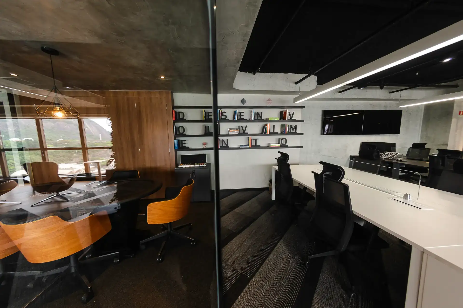 Sala de reunião envidraçada, estilo sala aquário, e estante decorativa, integrando elementos de projeto de arquitetura da Custódio em uma obra corporativa completa.