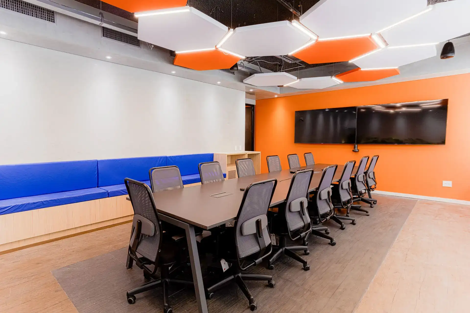 Sala de reunião da EDF em Macaé com mesa grande, cadeiras ergonômicas e painéis acústicos, resultado de um projeto de arquitetura corporativa completo.