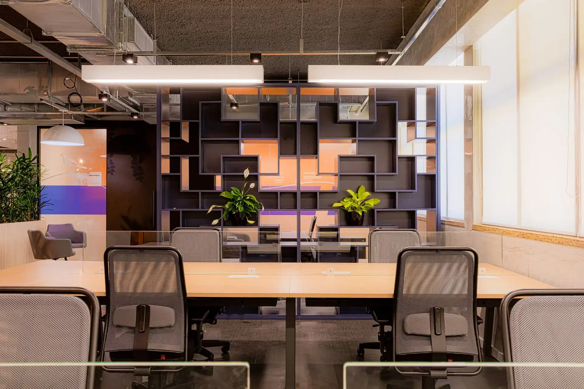 Divisória decorativa no escritório da EDF Macaé, parte do projeto de arquitetura que traz cores fortes e elementos geométricos ao ambiente.