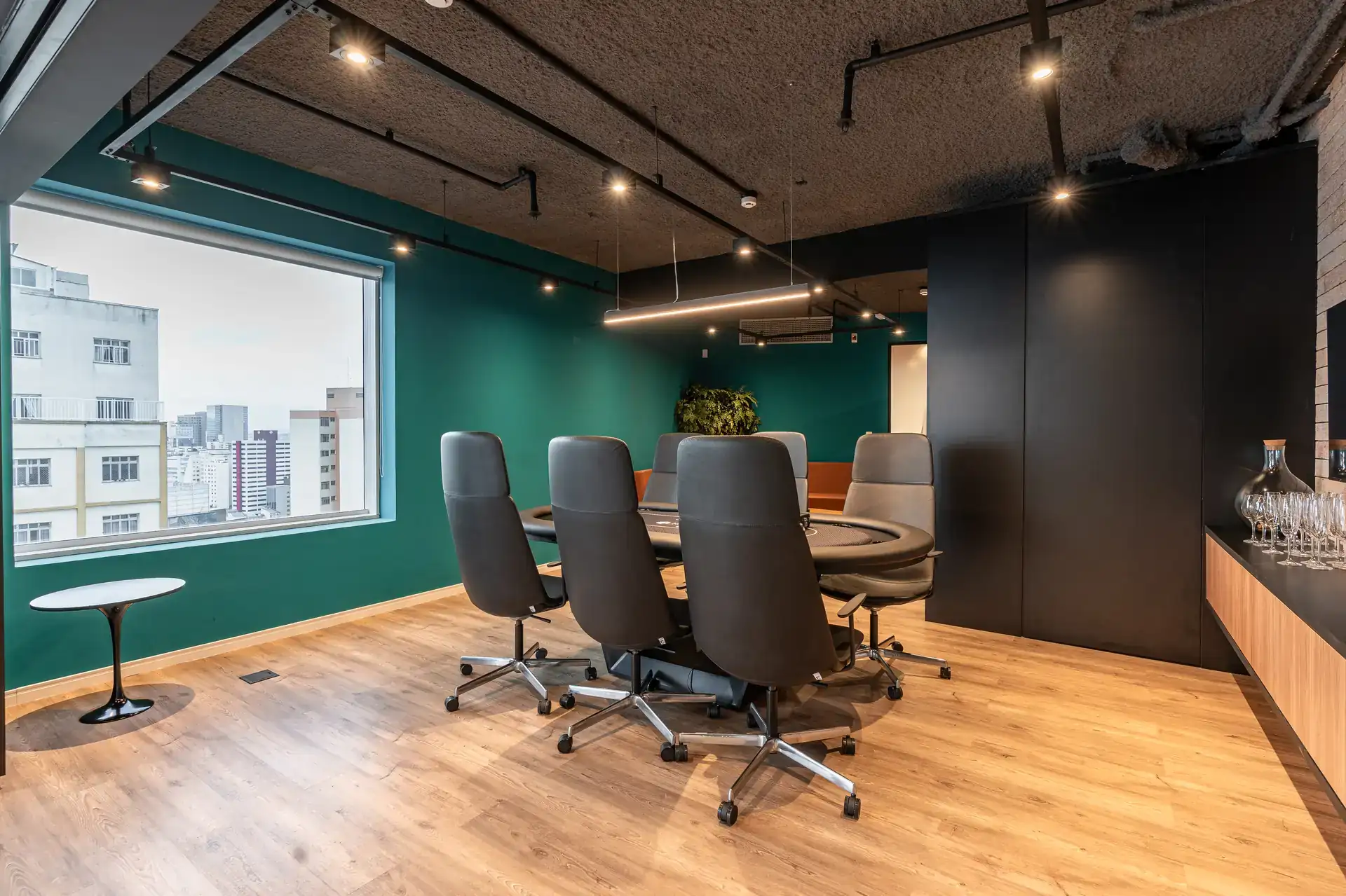 Sala de reunião com vista para a cidade, mesa ampla e cadeiras executivas, integrada ao projeto de arquitetura do escritório da MHM.