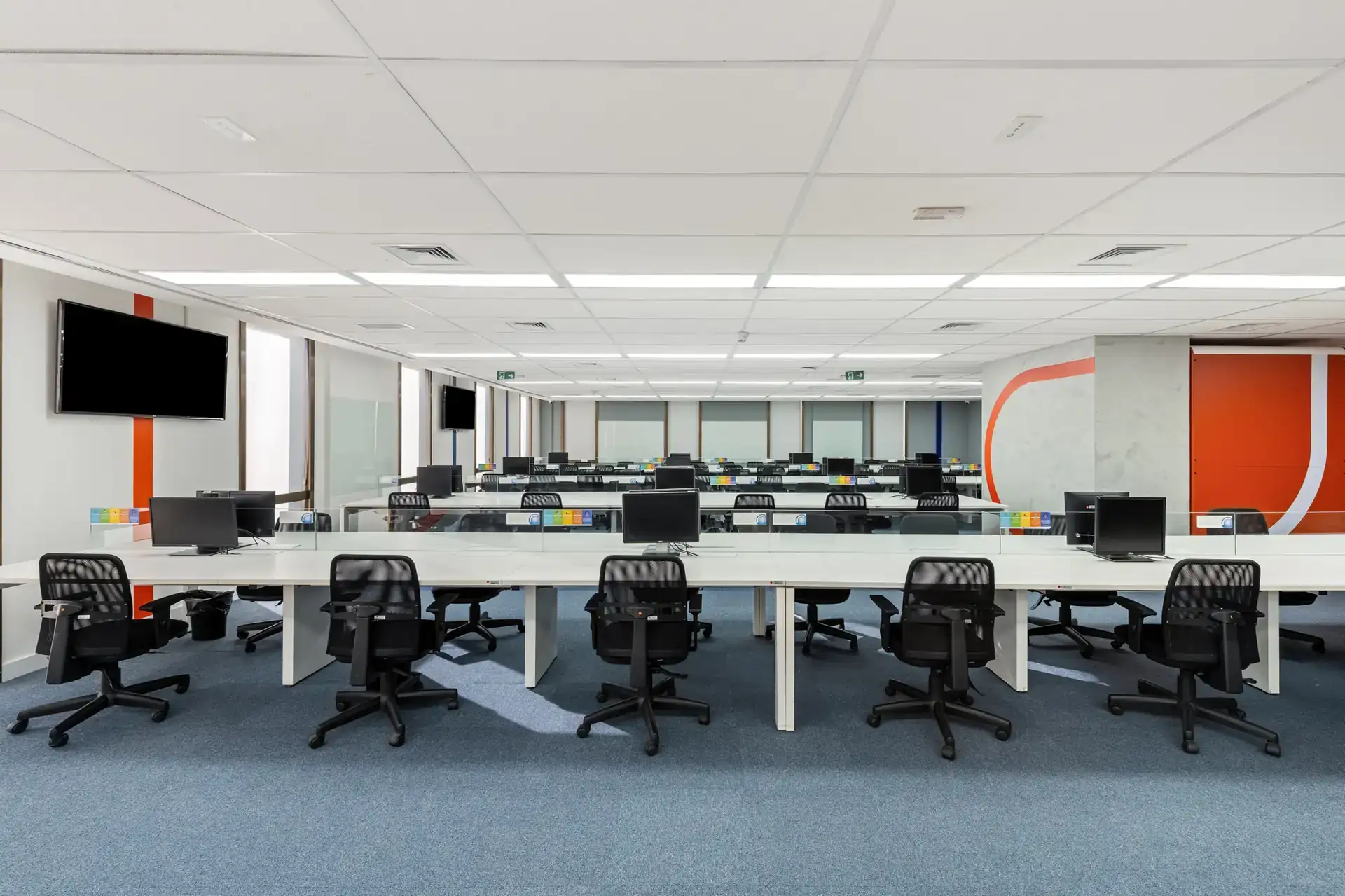 Ambiente operacional extenso do escritório da NSG com layout organizado, ilustrando um projeto de arquitetura e obra corporativa planejados para alta produtividade.