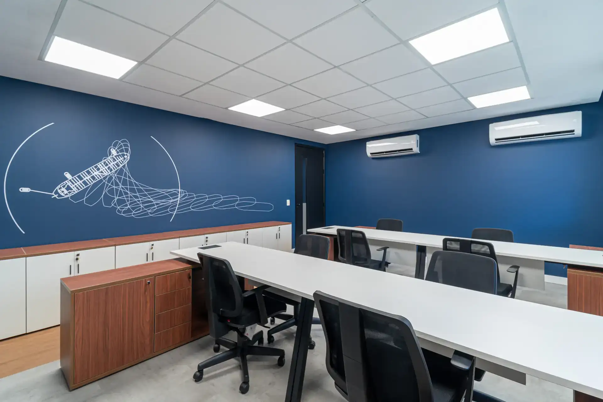 Escritório do SINDMAR com estações alinhadas, climatização dupla e mural técnico, entregue em projeto de arquitetura e obra corporativa.