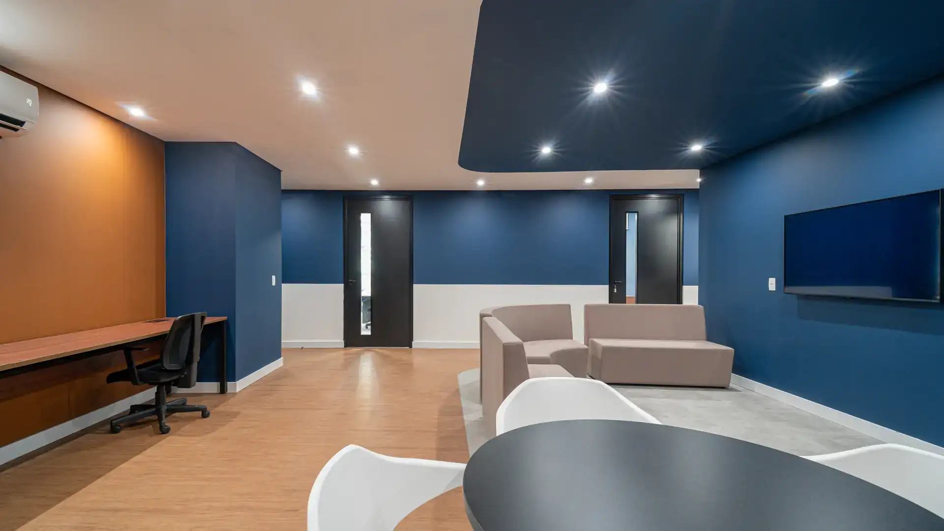 Sala de convivência com áreas de trabalho e descanso integradas, resultado de projeto de arquitetura funcional para escritórios.