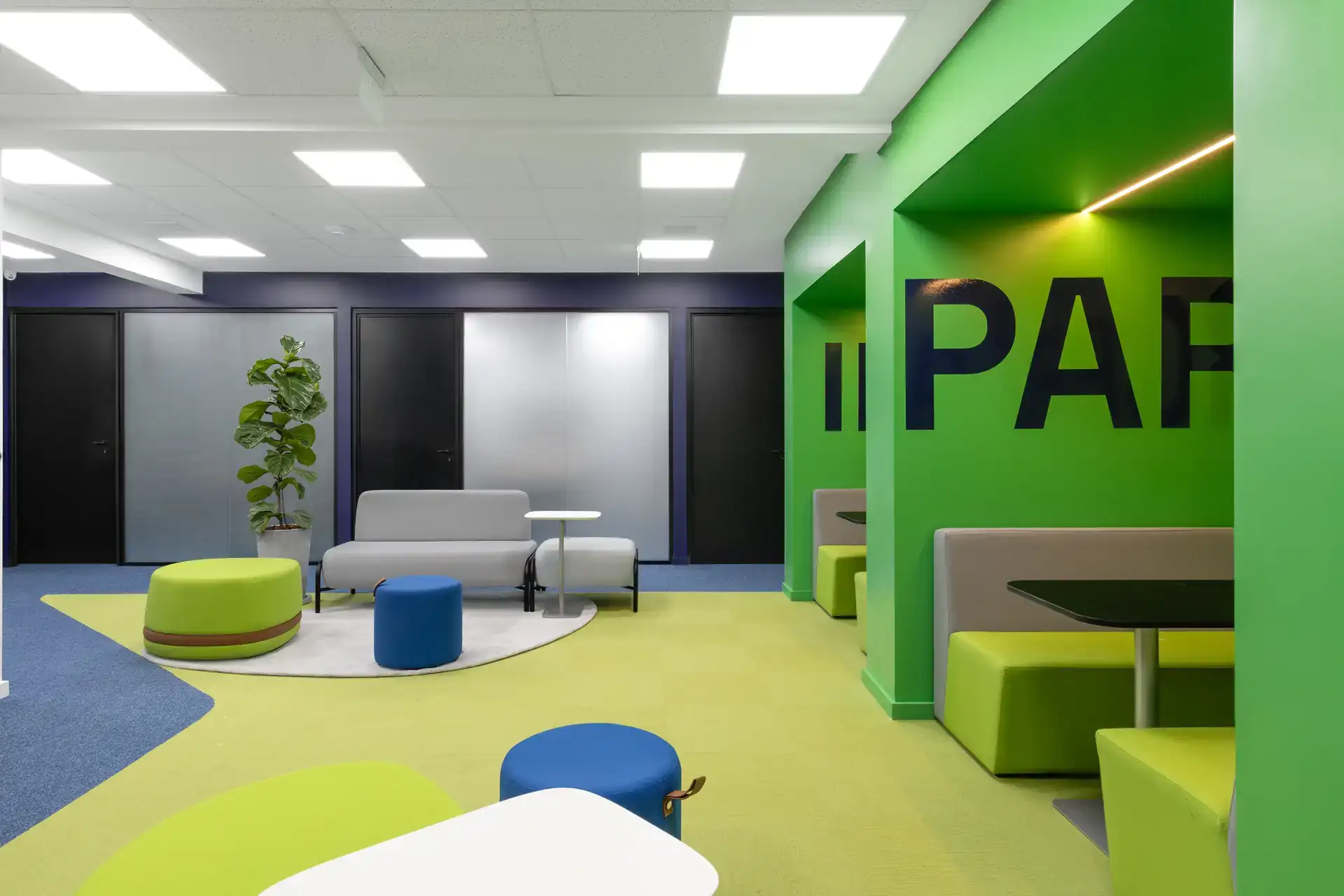 Área de descompressão colorida em escritório corporativo, com mobiliário moderno e projeto de arquitetura que integra espaços colaborativos na reforma do escritório Transit BR.