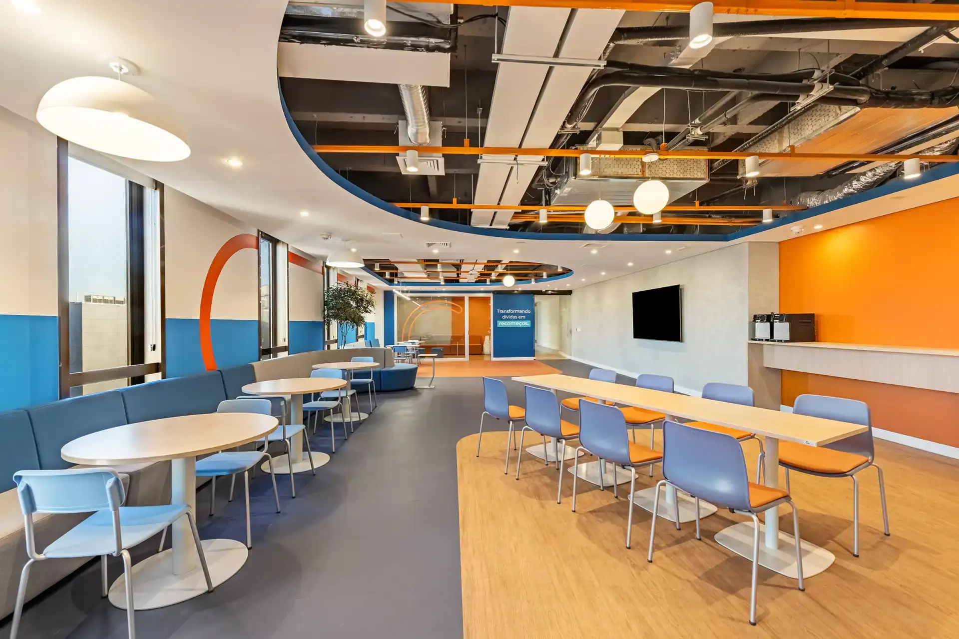 Área de café integrada ao espaço de convivência, com estética moderna e soluções arquitetônicas pensadas para grandes empresas. Executado em reforma corporativa com projeto de arquitetura e obra para o escritório da Recovery.