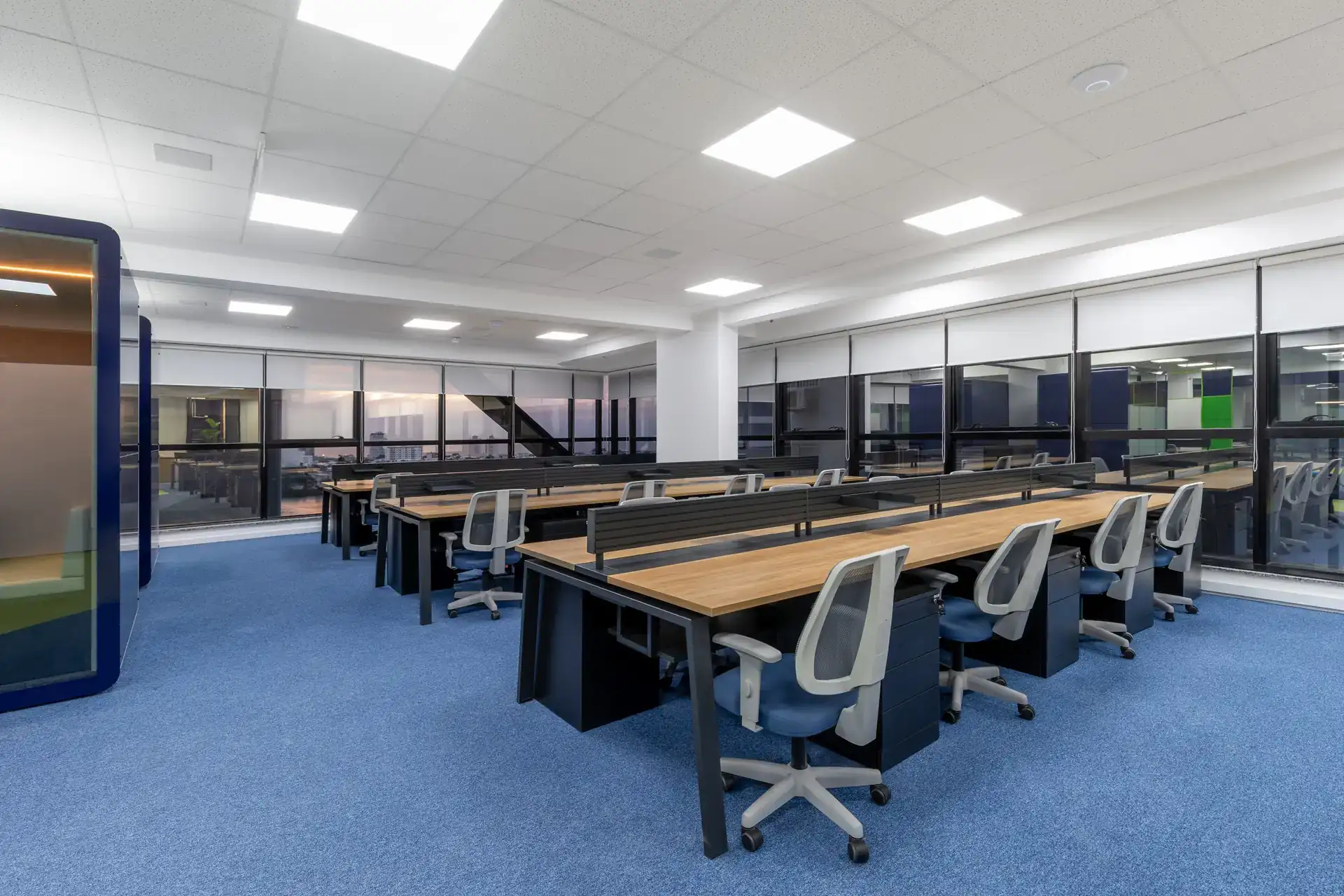 Open space amplo com estações de trabalho alinhadas, iluminação integrada e layout funcional, resultado de reforma corporativa integrada ao projeto de arquitetura da Transit BR.